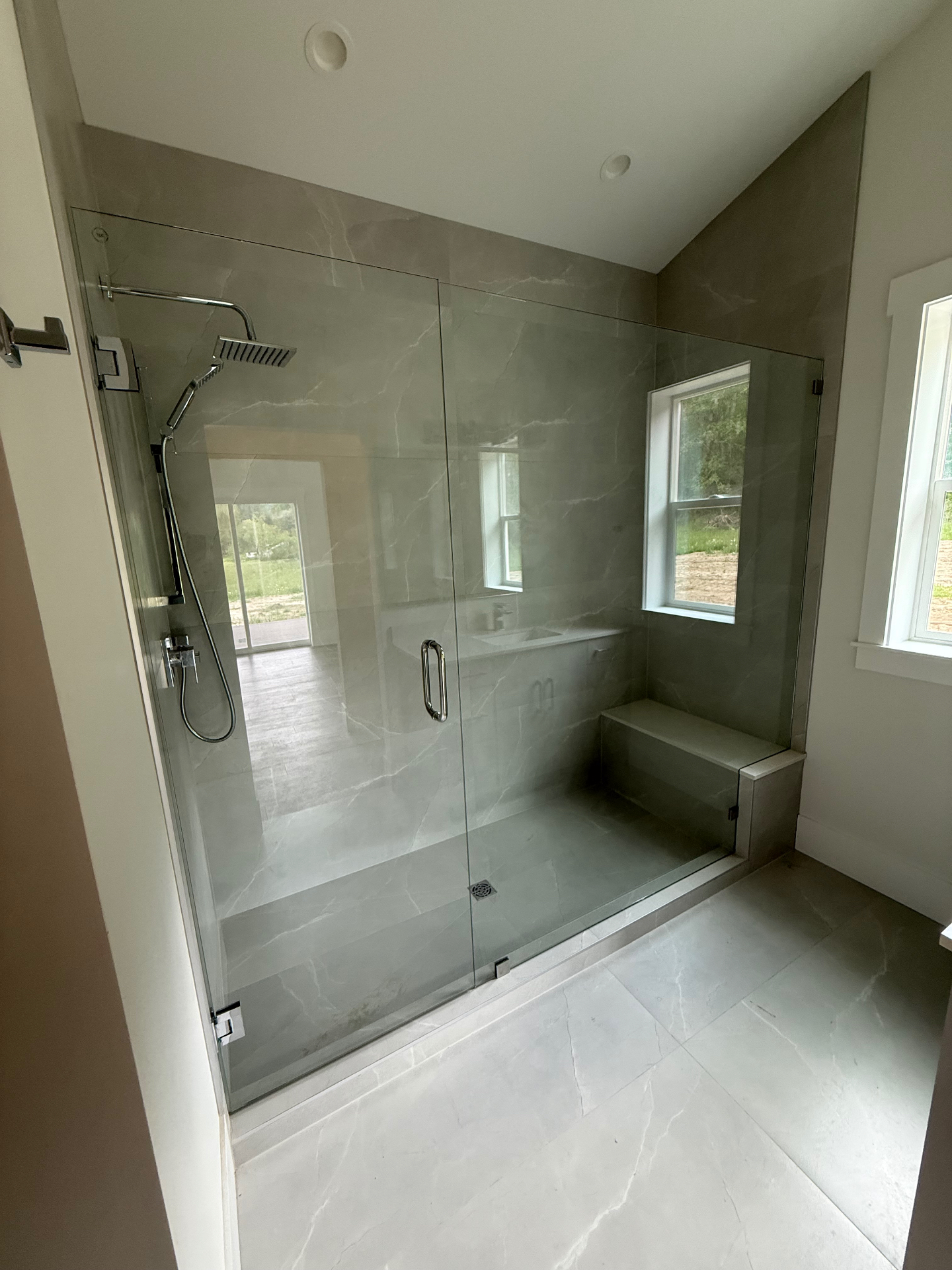 Walk-in tile shower with built-in bench and window