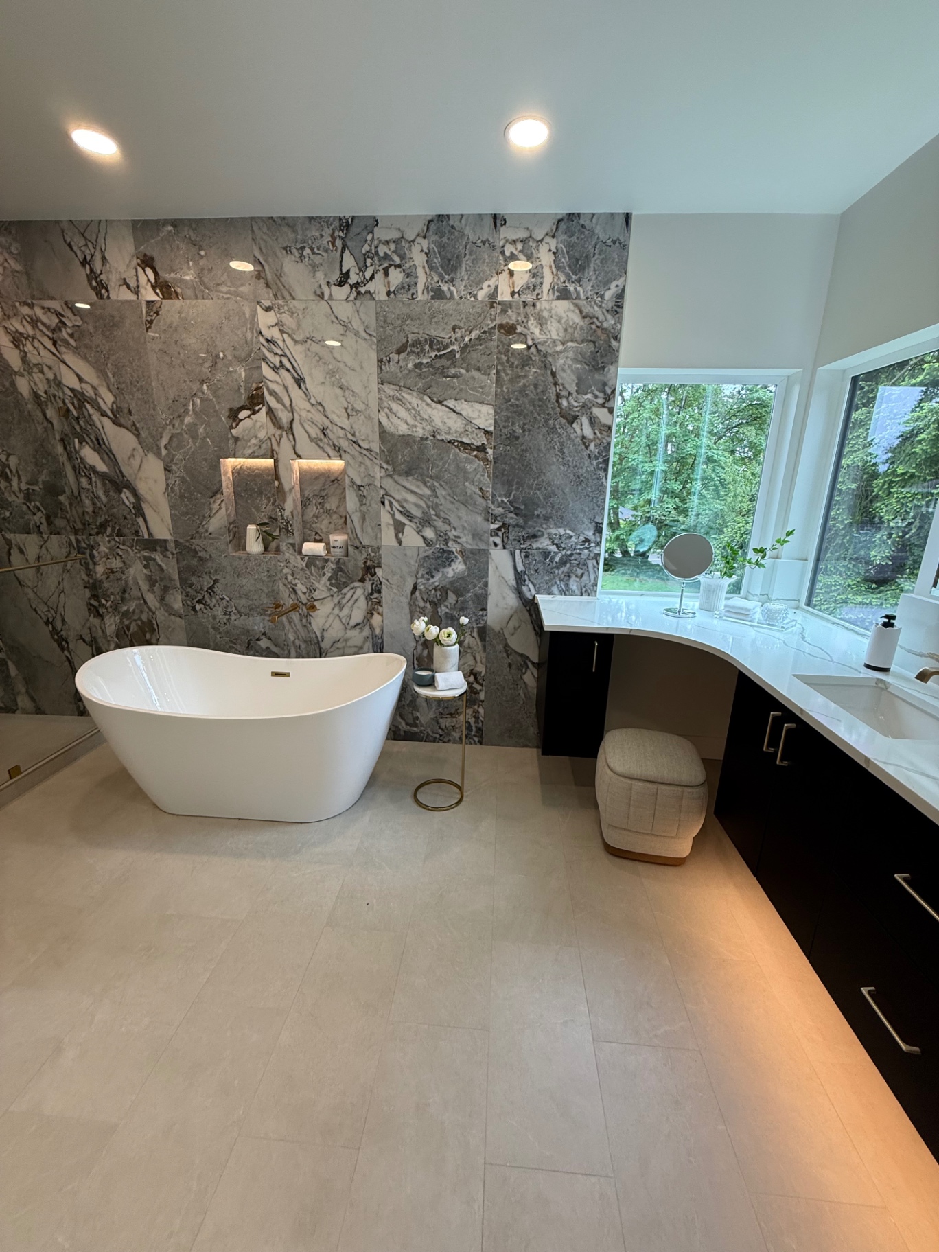 Luxury master bathroom with freestanding tub and marble feature wall